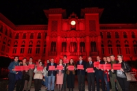 Las autoridades ante el Rectorado iluminado en rojo